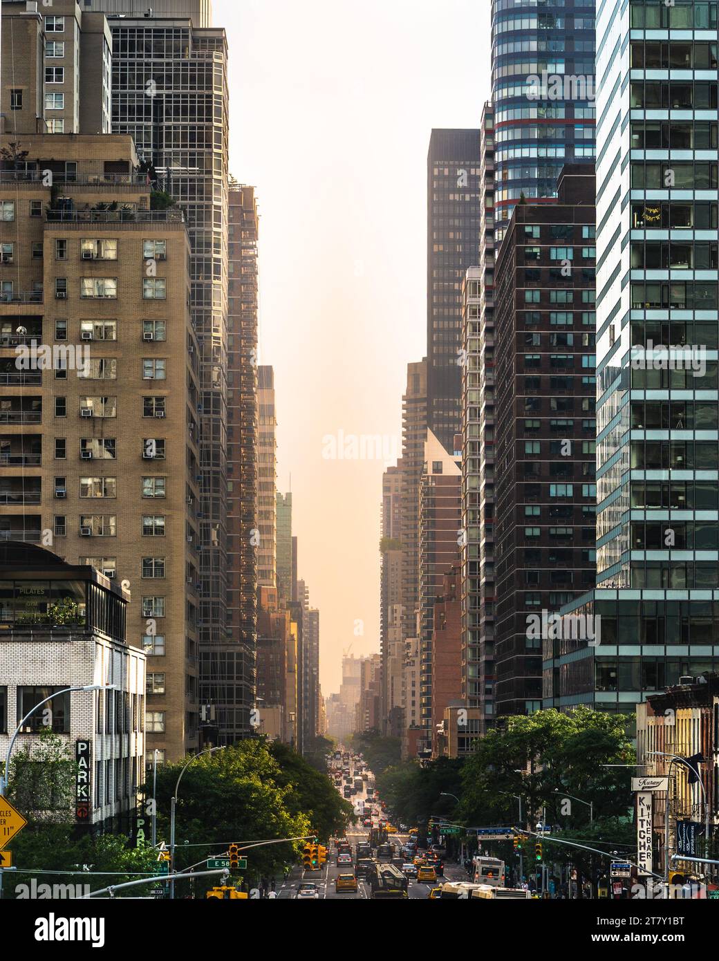 Una vivace strada cittadina piena di attività, con una pletora di edifici torreggianti, traffico vivace e gente che vive la propria vita quotidiana Foto Stock