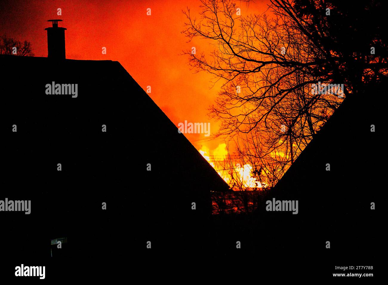 Le fiamme di un fuoco spettacolare al Lumberyard RK Miles a Montpelier, VT, New England, USA, visto dietro le case. Foto Stock