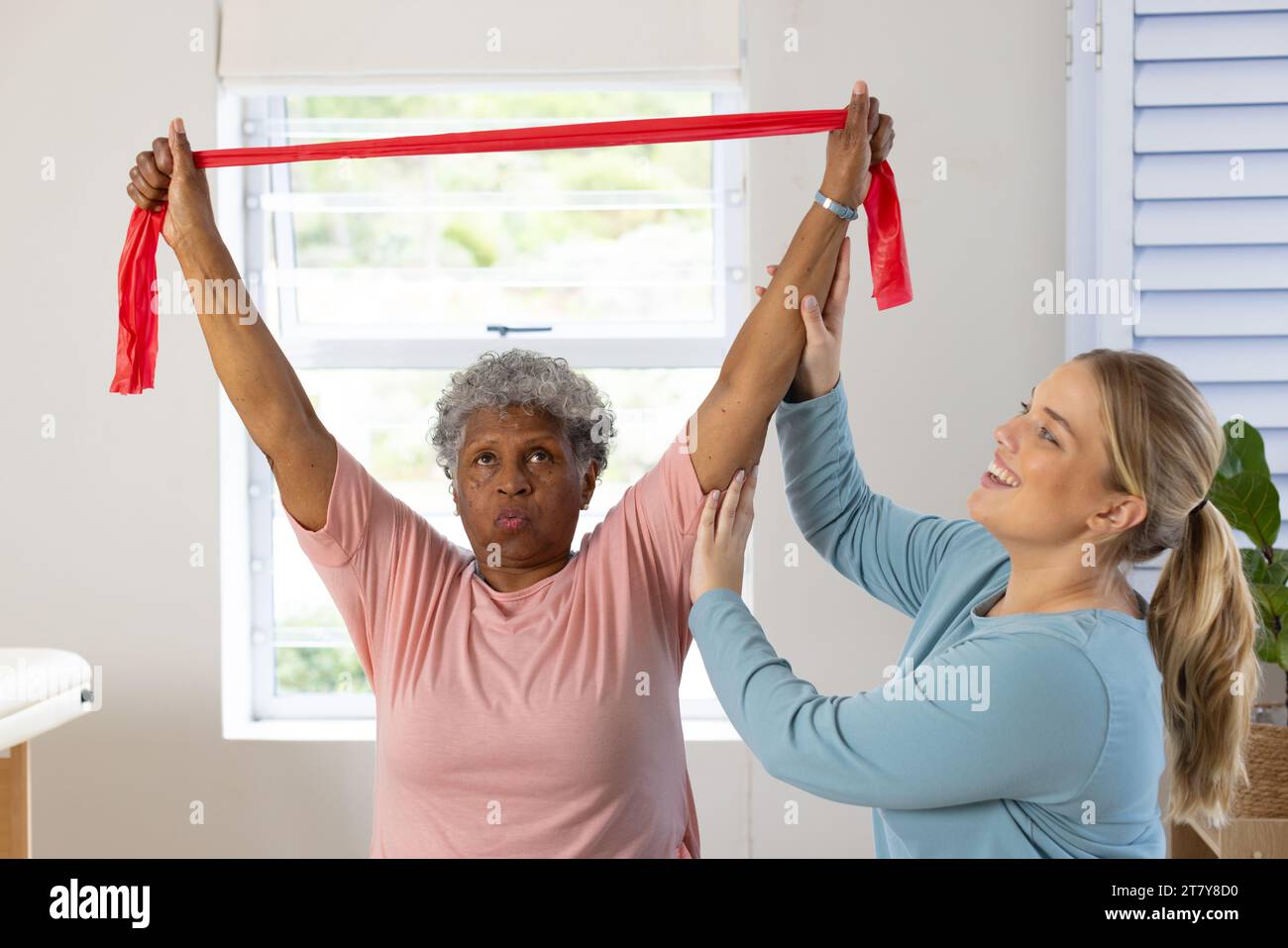 Fisioterapista femminile caucasica e paziente afrcia americana anziana con banda, spazio copia Foto Stock