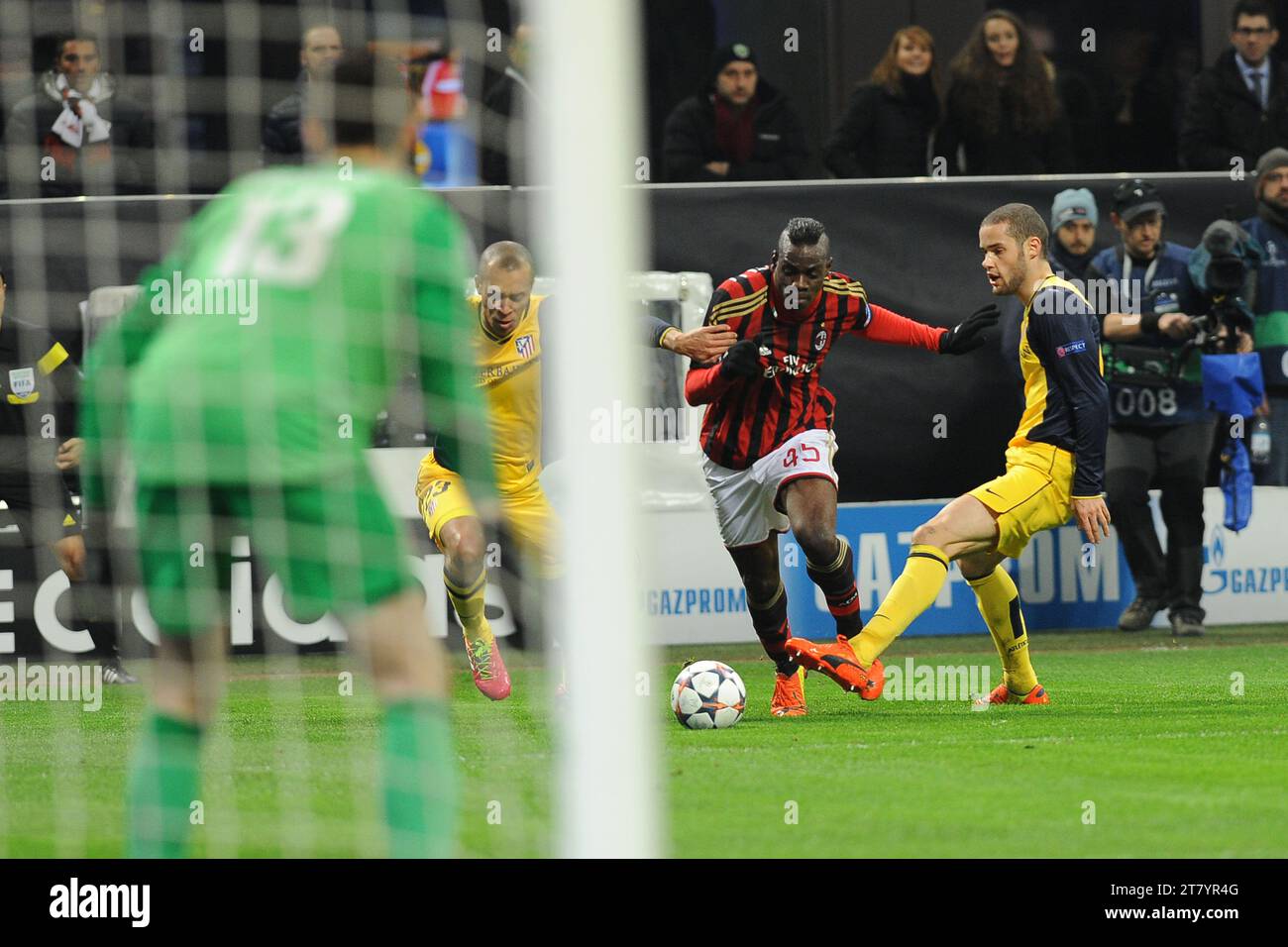 Mario Balotelli dell'AC Milan si batte con Miranda e Mario Suarez dell'Atletico de Madrid durante la partita di UEFA Champions League 2013/2014 round 16 andata tra l'AC Milan e l'Atletico Madrid il 19 febbraio 2014 allo stadio Giuseppe Meazza di Milano. Foto massimo Cebrelli / DPPI Foto Stock