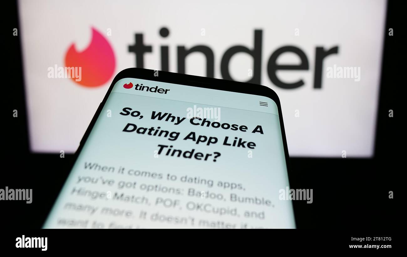 Smartphone con sito web dell'app di incontri online degli Stati Uniti Tinder davanti al logo aziendale. Mettere a fuoco in alto a sinistra sul display del telefono. Foto Stock