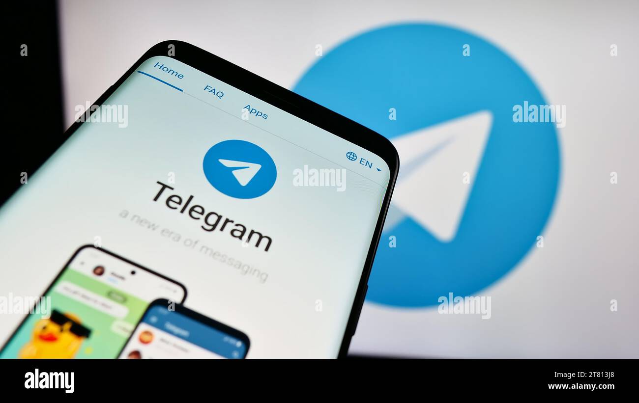 Telefono cellulare con sito Web del servizio di messaggistica istantanea Telegram Messenger davanti al logo. Mettere a fuoco in alto a sinistra sul display del telefono. Foto Stock