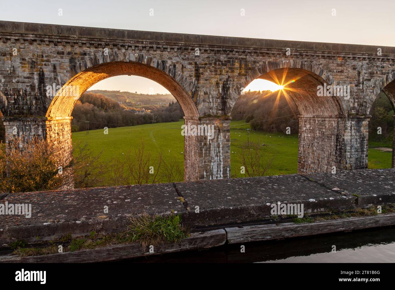 I raggi del sole che tramonta brillano attraverso gli archi del viadotto ferroviario della valle di Ceiriog. Costruito nel 1848 e progettato dall'ingegnere cheif per i Shrews Foto Stock