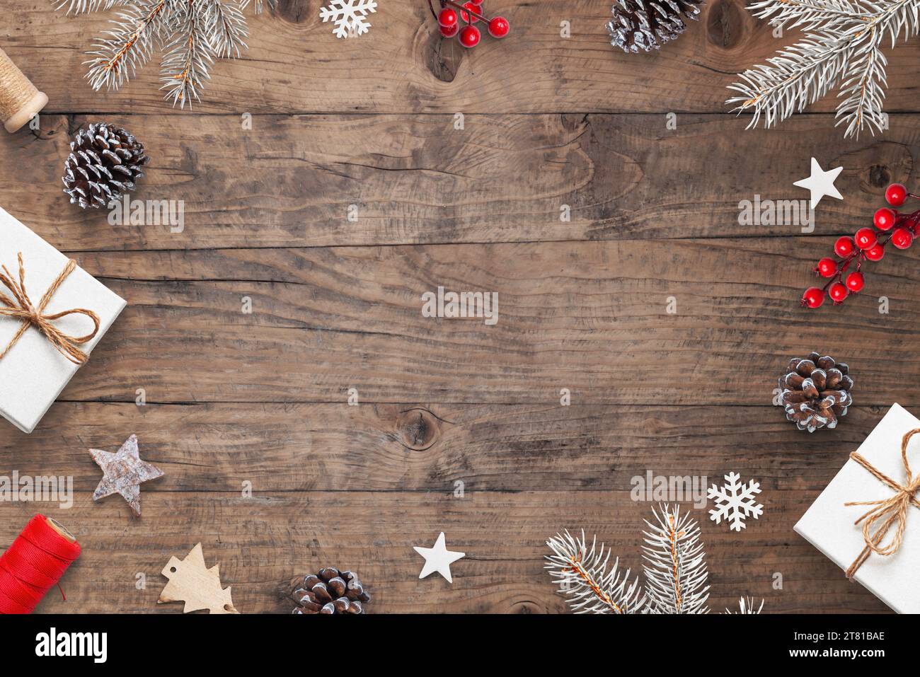 Banco di Natale con decorazioni natalizie, rami d'albero, regali e spazio per le copie. Sfondo in legno con atmosfera da vacanza Foto Stock