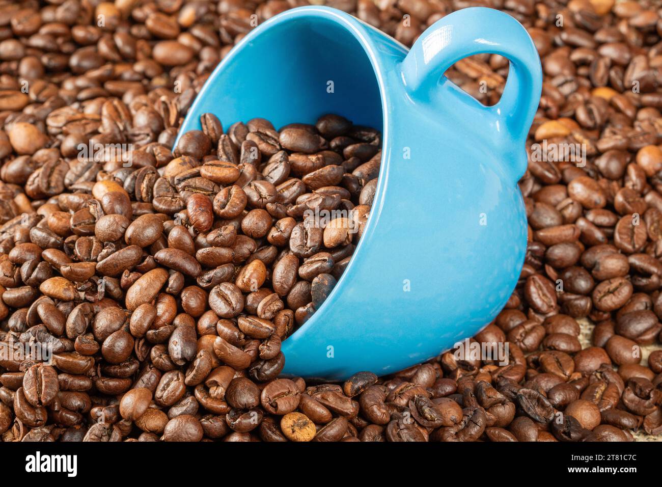 Tema del caffè. Tazza di caffè blu riempita a metà con chicchi di caffè. Foto Stock