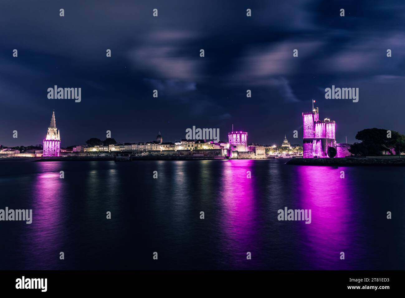 Vista panoramica del porto vecchio la Rochelle con le sue famose torri. Notte con luci rosa per ottobre rosa. Ottobre rosa è cancro al seno consapevole Foto Stock
