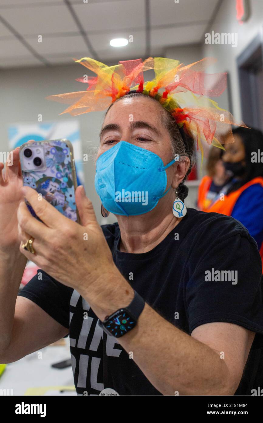 Dearborn, Michigan - Una donna che indossa una maschera facciale e una decorazione della testa scatta una foto con il suo cellulare. Foto Stock