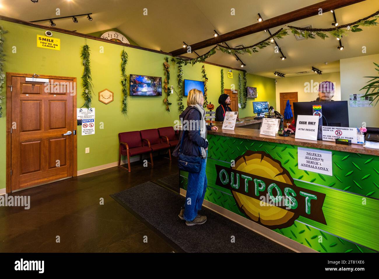 All'interno dell'area vendite di Outpost Marquette, un rivenditore ufficiale di cannabis a Marquette Township, Michigan, Stati Uniti, un membro dello staff serve un cliente al bancone. Foto Stock