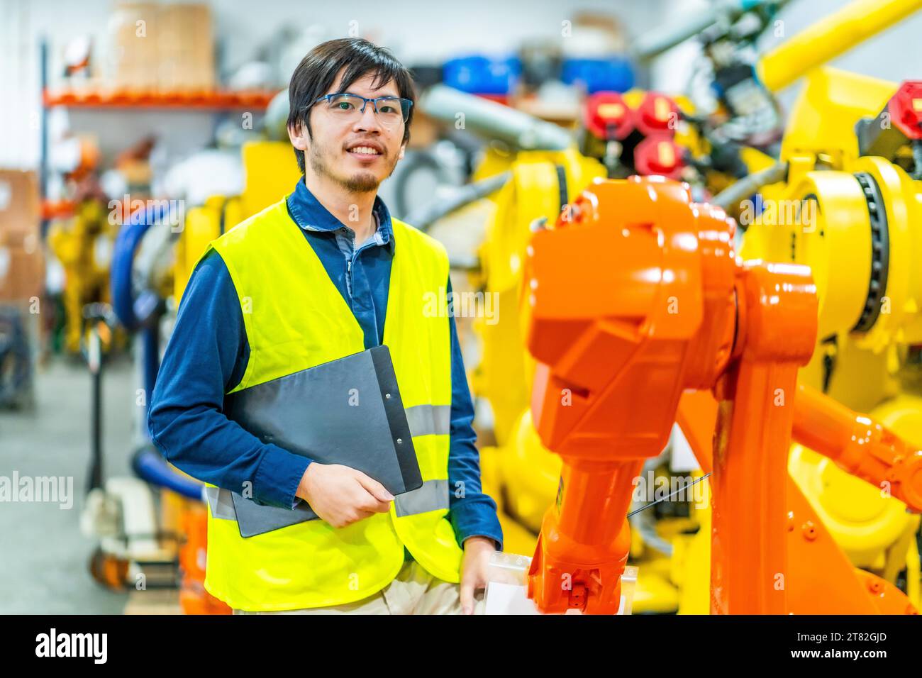 Ritratto di un giovane ingegnere giapponese intelligente in un'industria robotica Foto Stock