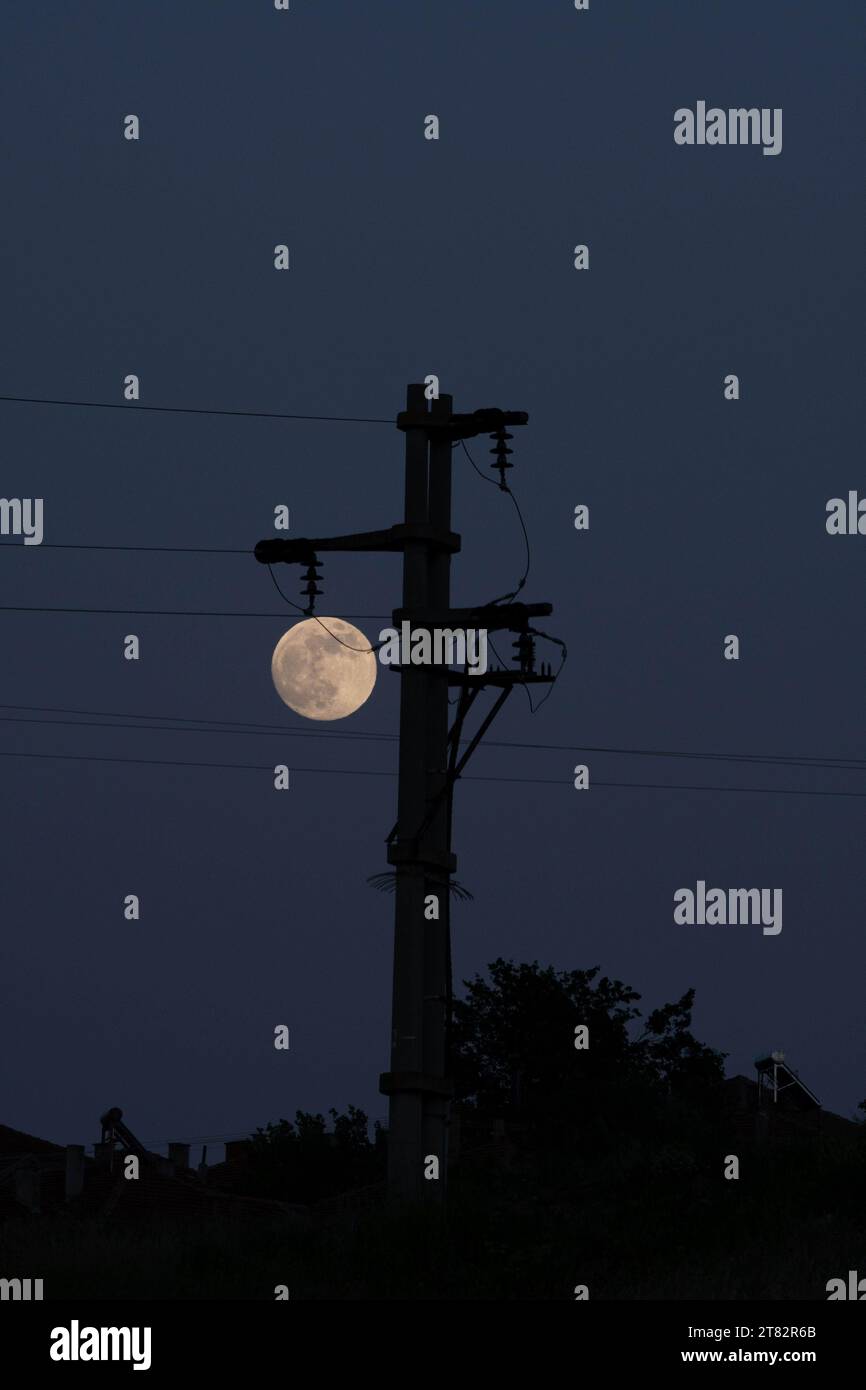 Luna piena, fase. Come lampadina astratta lampione. Bagliore al buio. Cavi, fili. Foto Stock