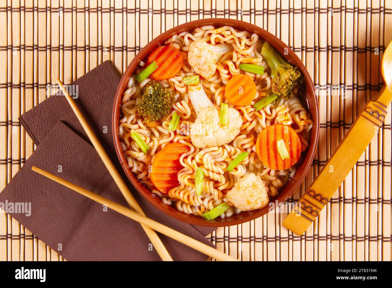 Al ristorante vengono serviti piatti asiatici in una ciotola su tappeti di bambù. Foto Stock