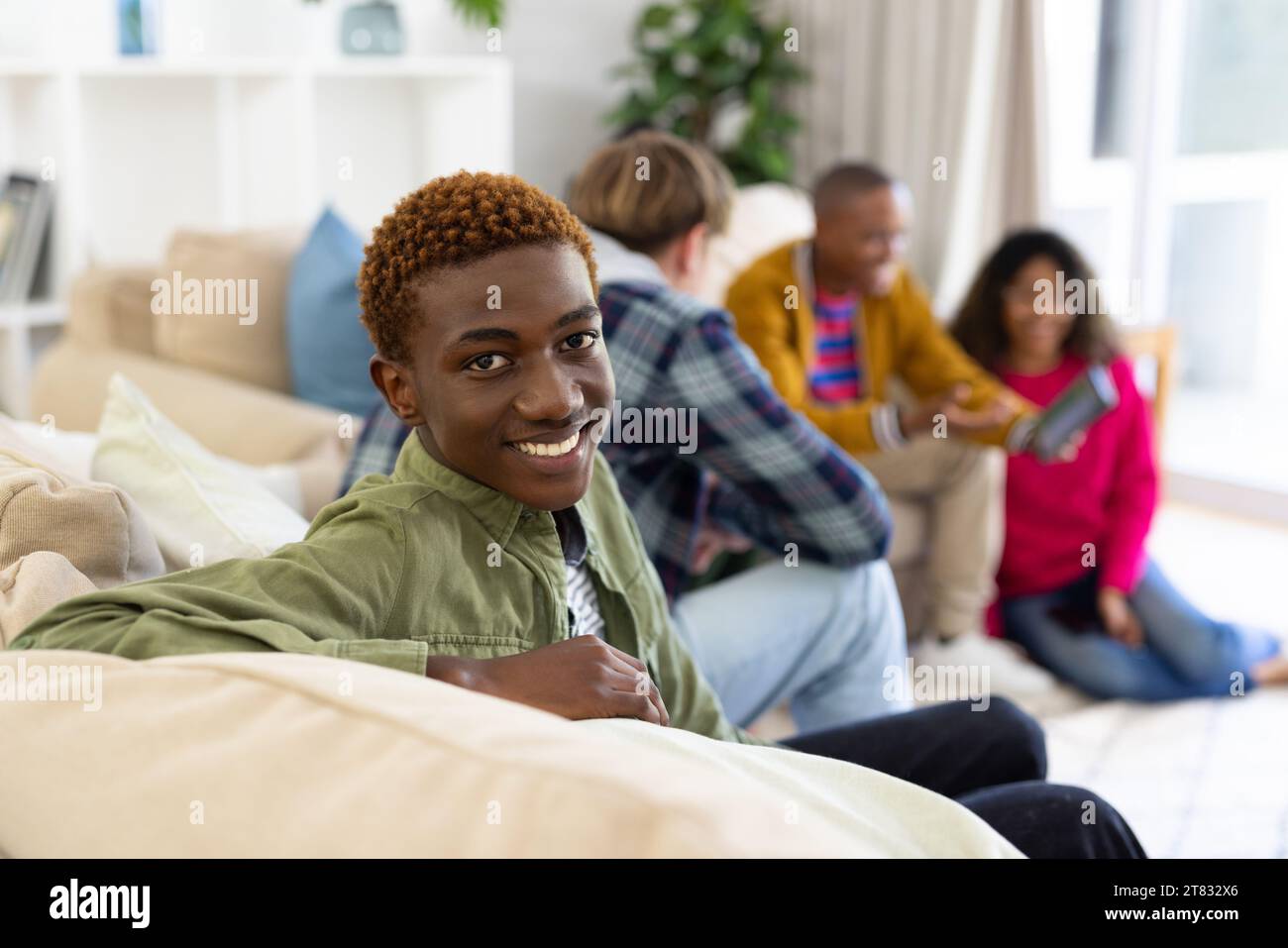 Ritratto di un gruppo eterogeneo di amici adolescenti che usano il tablet e parlano a casa Foto Stock