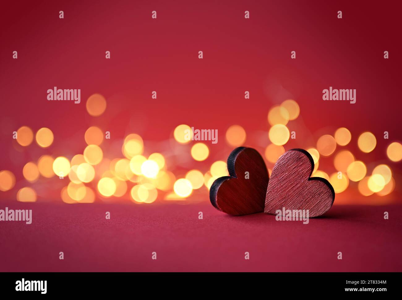Due valentine rosse cuori di legno su sfondo rosso. Foto Stock