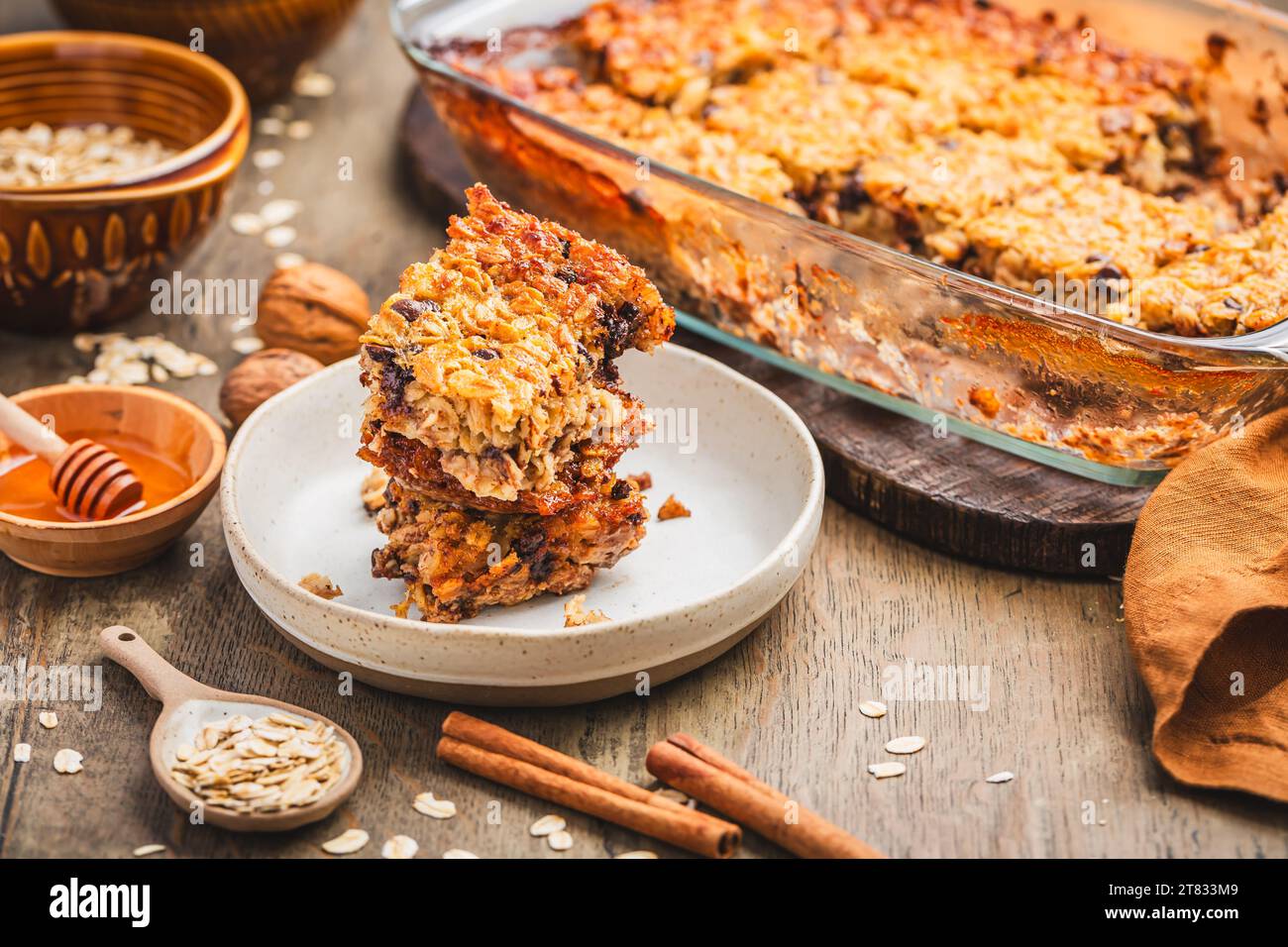 Farina d'avena vegana, pane alla banana o scatola con noci su un tavolo da cucina in legno Foto Stock