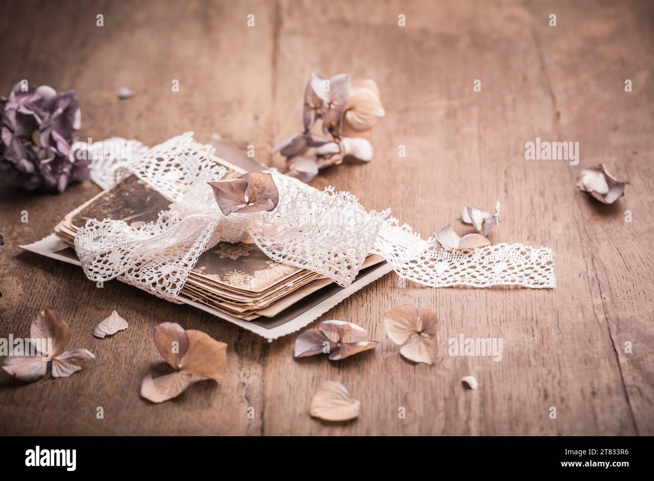 Ricordi, antiche e vecchie foto di famiglia con fiori secchi in stile vintage su un tavolo di legno Foto Stock