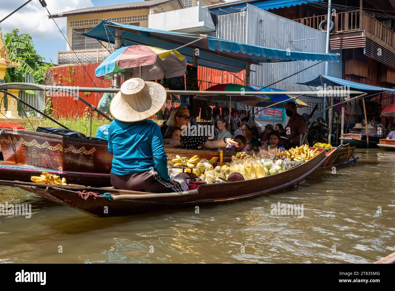 Vari beni, come cibo o bevande tailandesi, sono offerti in vendita su un mercato galleggiante originale Samut Sakhon Thailandia Asia Foto Stock