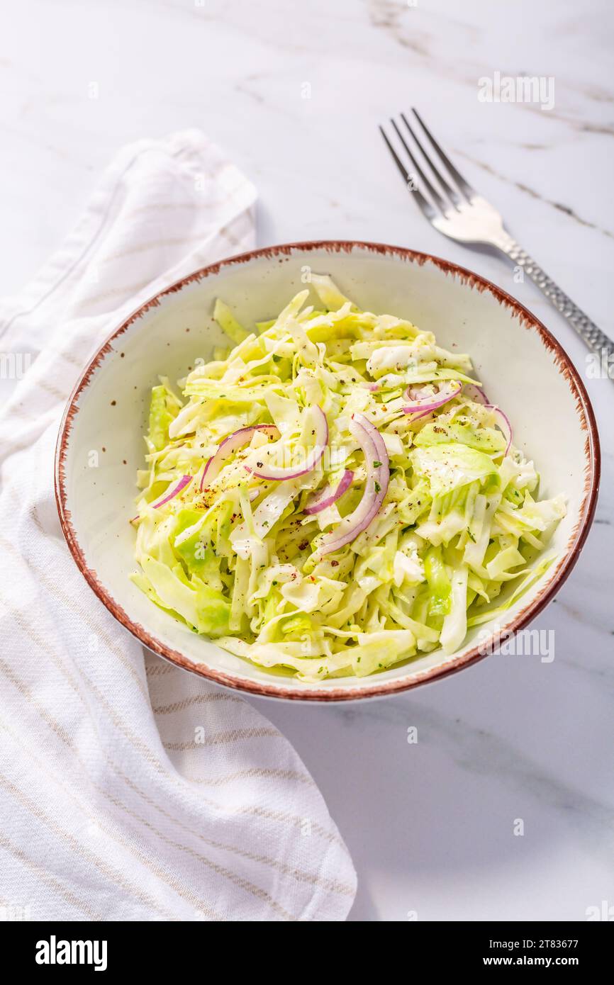 Insalata vegana di cavolo bianco appena tagliato con cipolle rosse Foto Stock
