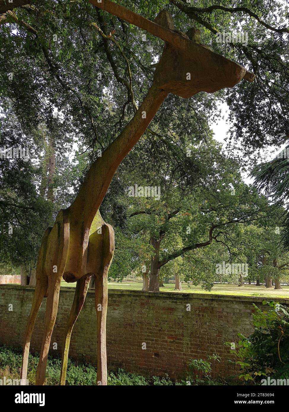 Primo piano di una statua di una giraffa in un ambiente boschivo. Foto Stock