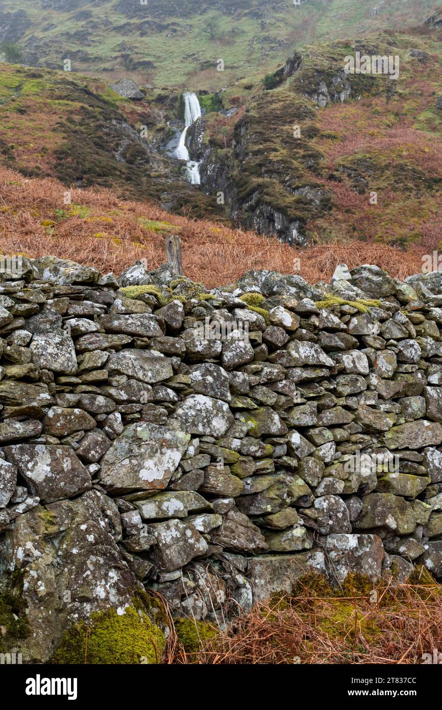 Tradizionale muro in pietra a secco sulle montagne del Galles del Nord con cascata di Rhaeadr Bach sullo sfondo. Foto Stock