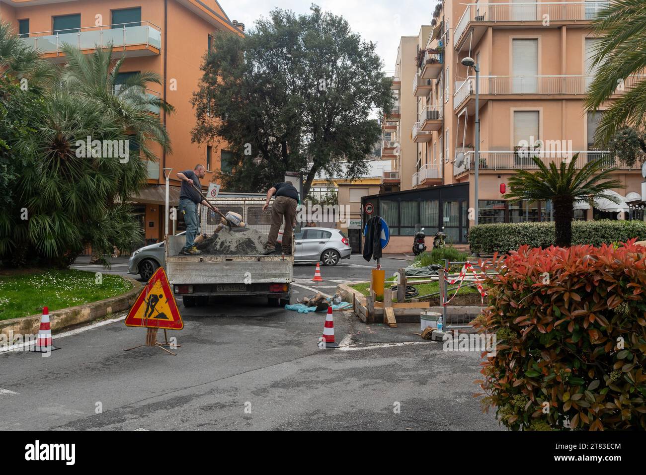 Operai comunali su furgone per la ricostruzione del cordolo di un divisore di traffico inondato nel centro di finale Ligure, Savona, Liguria, Italia Foto Stock