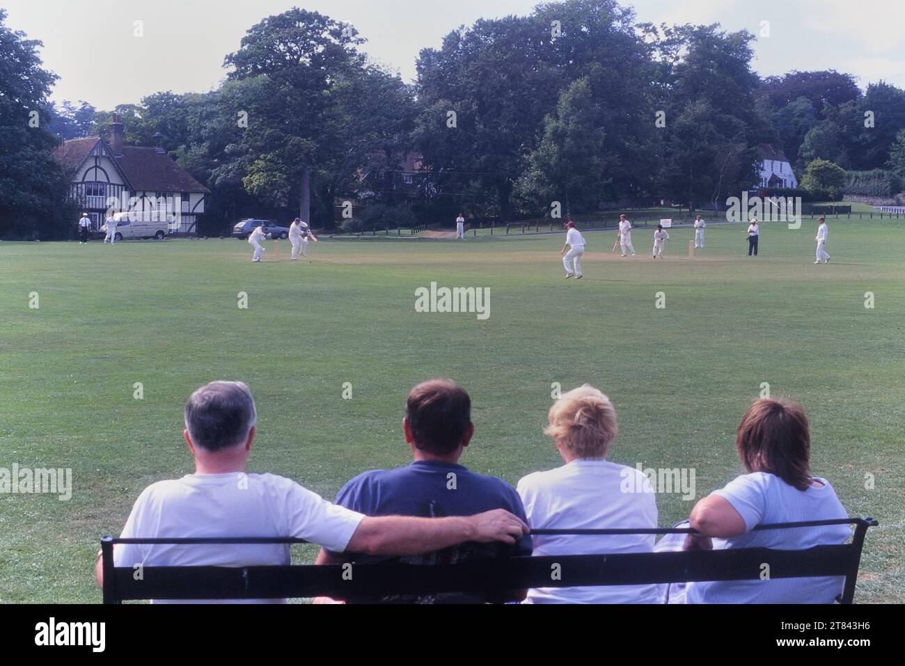 Spettatori in un idilliaco campo da cricket e gioco del villaggio. The Green, Bearsted, Kent, Inghilterra, Regno Unito Foto Stock