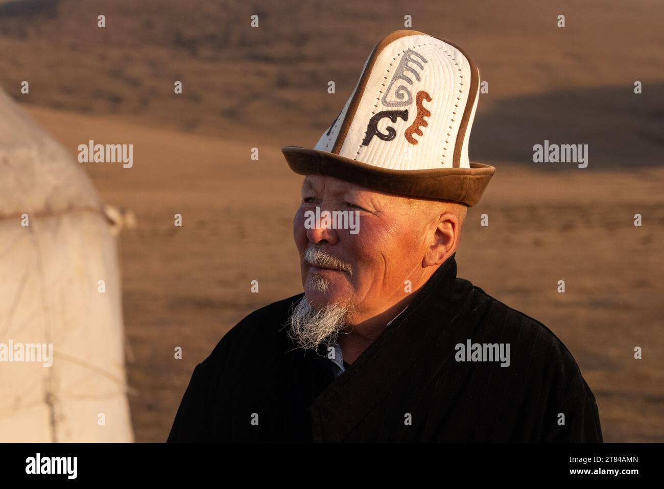 Campo di yurte sul lago Song Kul in Kirghizistan uomo locale in abiti tradizionali Foto Stock