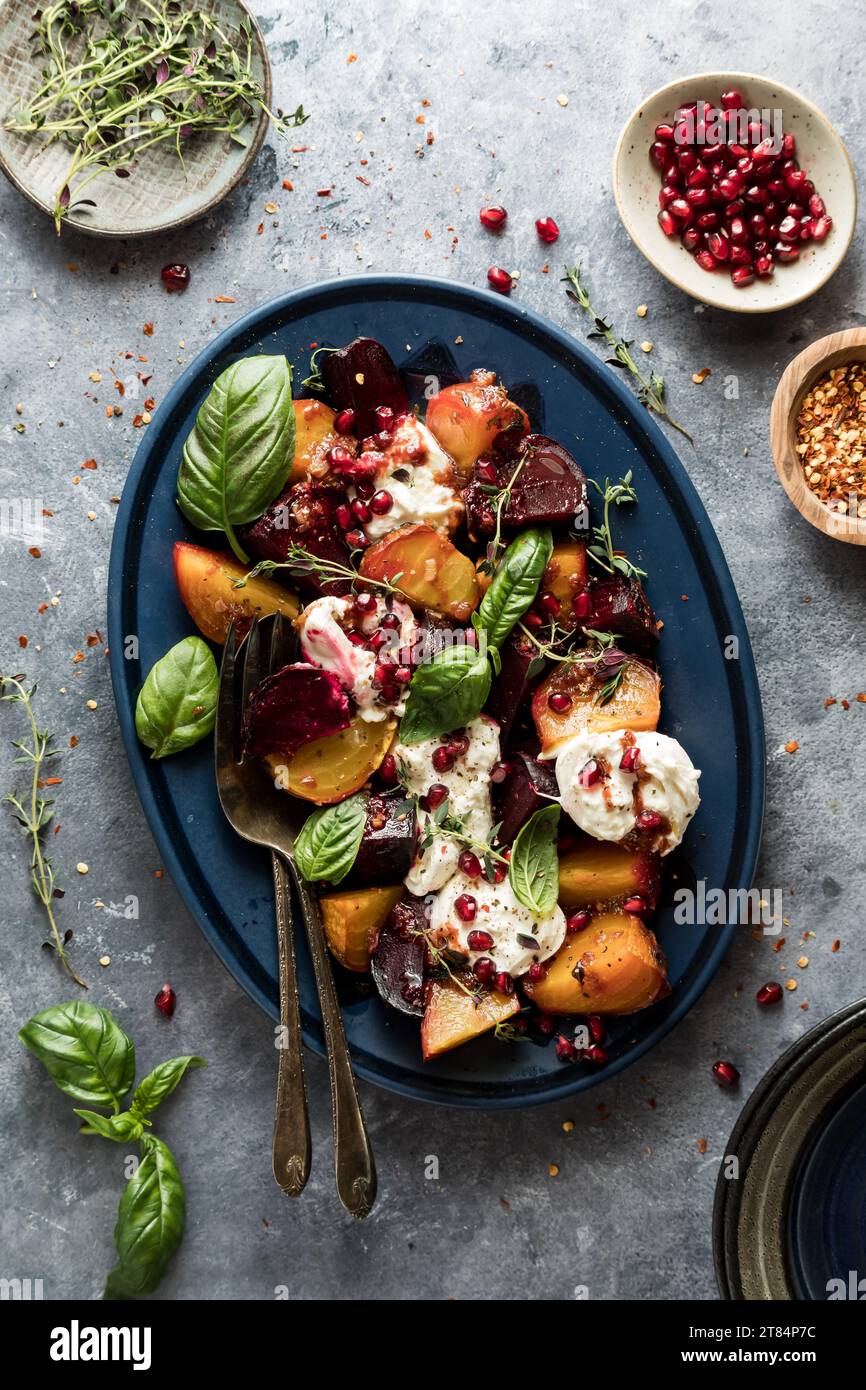 Barbabietole arrostite con burrata condite con erbe e semi di melograno. Foto Stock