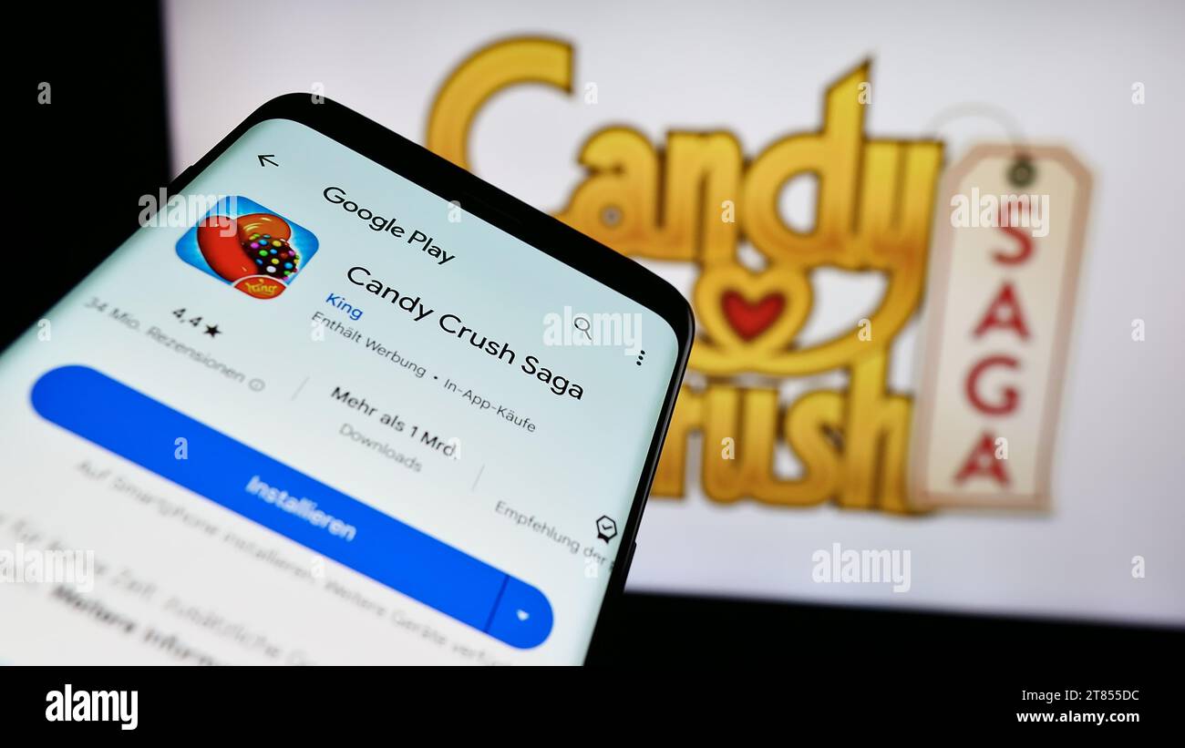 Smartphone con sito Web del videogioco Candy Crush Saga in corrispondenza di piastrelle davanti al logo. Mettere a fuoco in alto a sinistra sul display del telefono. Foto Stock
