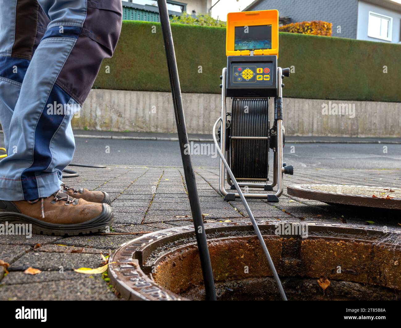 Un'azienda di pulizia degli scarichi controlla uno scarico ostruito con una telecamera prima di lavarlo fuori Foto Stock