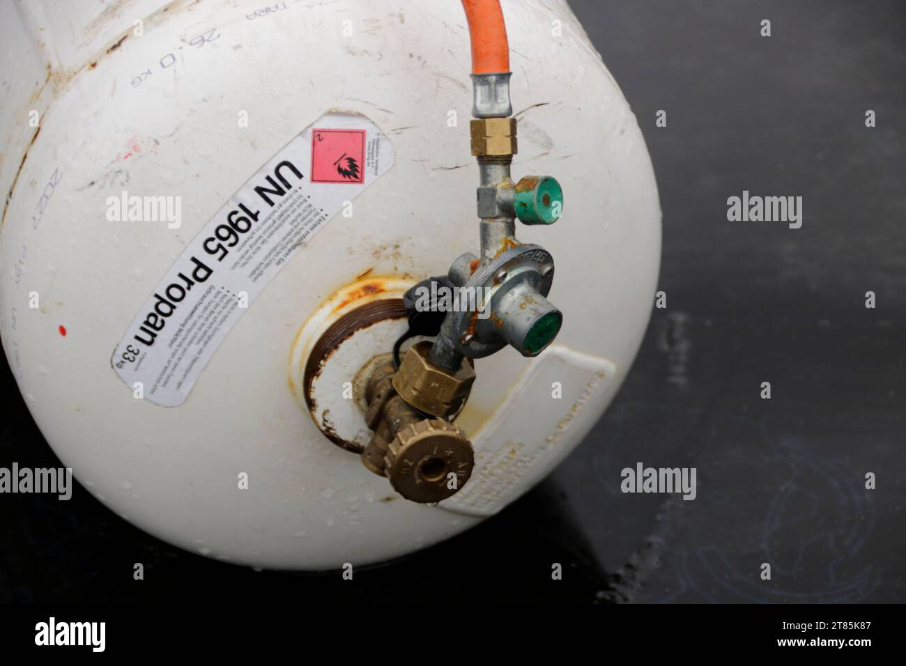 La bombola di gas con valvola senza protezione si trova sul pavimento Foto Stock