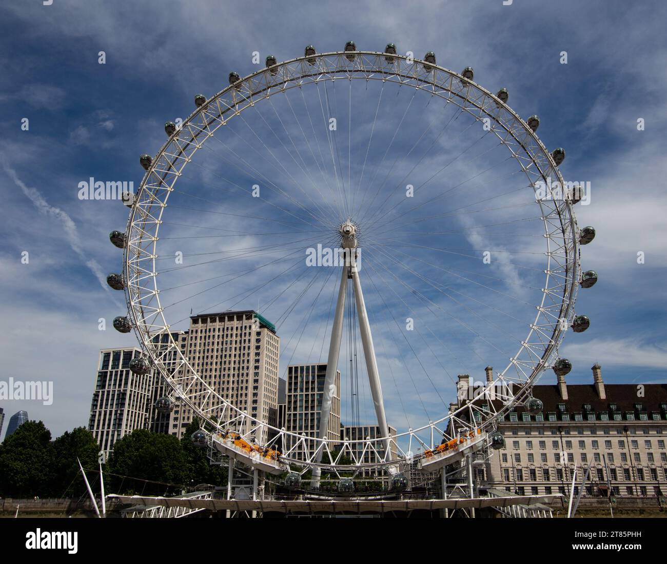 Riprese grandangolari della ruota panoramica del London Eye con capsule passeggeri contro un cielo nuvoloso Foto Stock