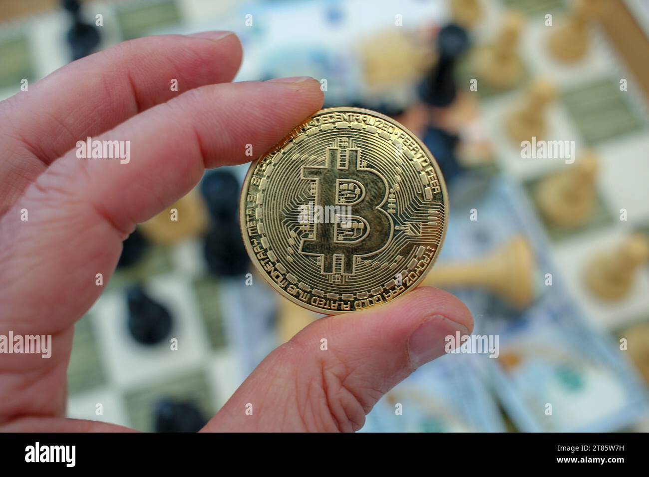 un bitcoin tra le mie dita. Concetto, bitcoin come opzione per investire in tempi di crisi e incertezza Foto Stock