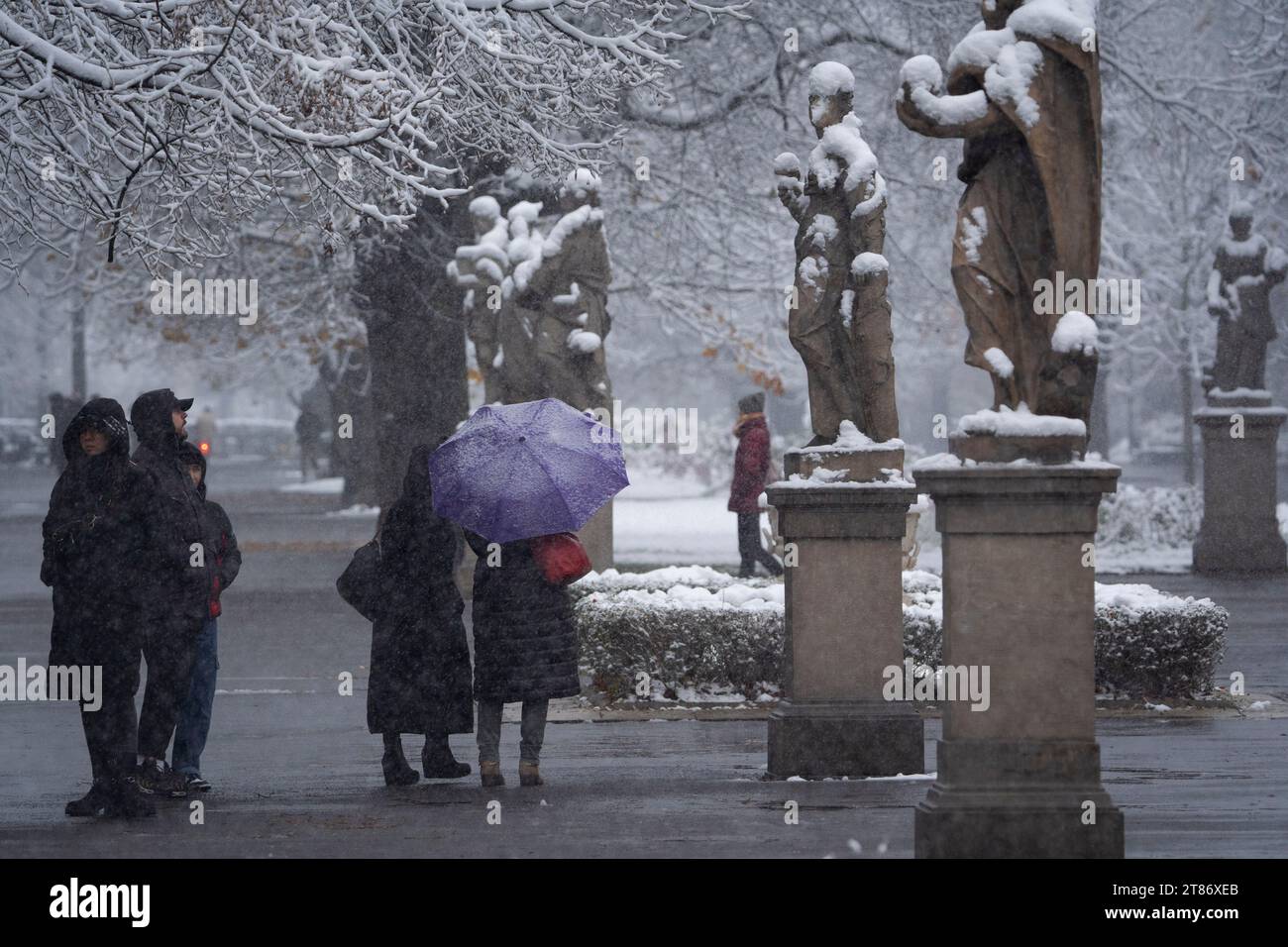 Varsavia, Polonia. 18 novembre 2023. I peopel con un unbrella sono visti camminare sotto gli alberi innevati nel parco sassone di Varsavia, in Polonia, il 18 novembre 2023. Credito: SIPA USA/Alamy Live News Foto Stock