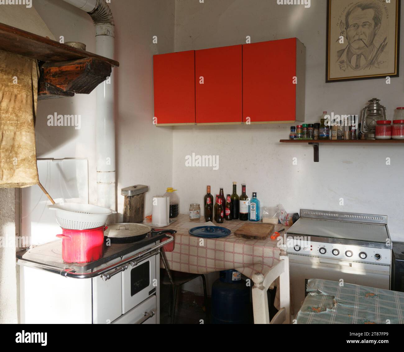 Interno di un'antica casa di campagna con armadi rossi e un fornello nel comune di Montefiascone, regione Lazio, Italia Foto Stock