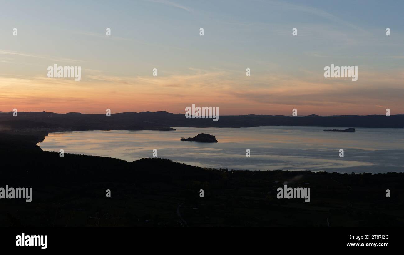 Ammira il tranquillo lago di Bolsena da Montefiascone in una giornata autunnale che si avvicina al tramonto, regione Lazio, Italia. Novembre 2023 Foto Stock