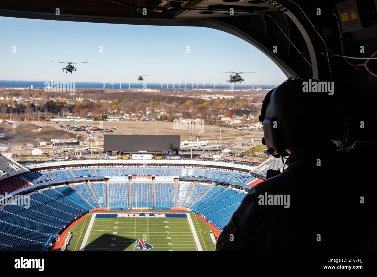 SPC Timothy Anderson, della 10th Combat Aviation Brigade, 3-10 General Support Aviation Battalion osserva una formazione aeronautica che vola sopra l'Highmark Stadium a Orchard Park, NY il 18 novembre 2023. Questo volo è una corsa di allenamento per la partita NFL Jets vs. Bills il 19 novembre. 2023. Foto Stock