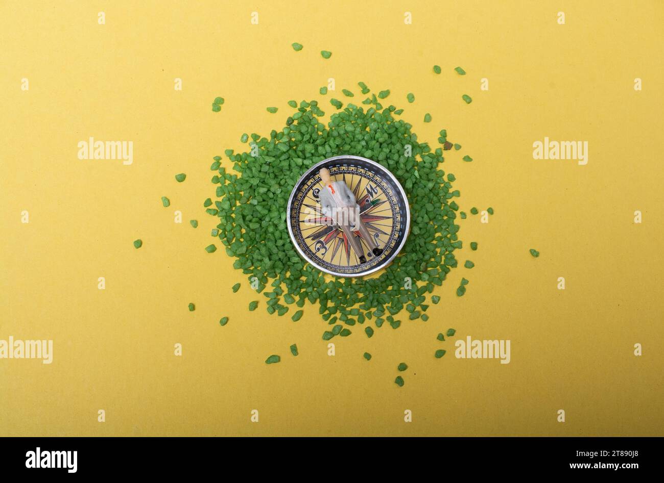 Una piccola figurina maschile posta sulla bussola per i concetti di navigazione Foto Stock