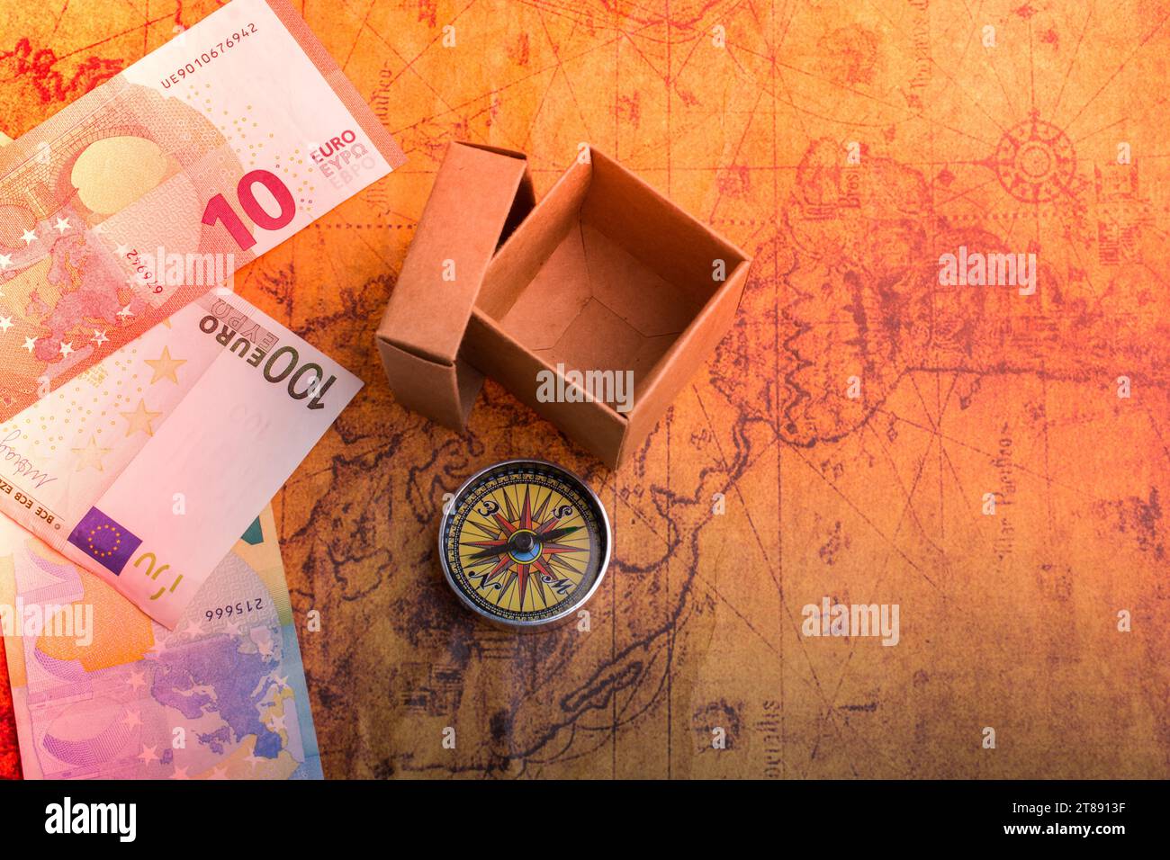 Bussola, scatola e banconote in euro sulla mappa come concetto di business Foto Stock