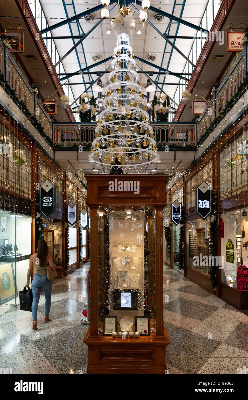 Un'unica donna che fa shopping natalizio cammina lungo Brisbane Arcade godendosi l'atmosfera di una delle gallerie dello shopping più iconiche della città di Brisbane. Foto Stock