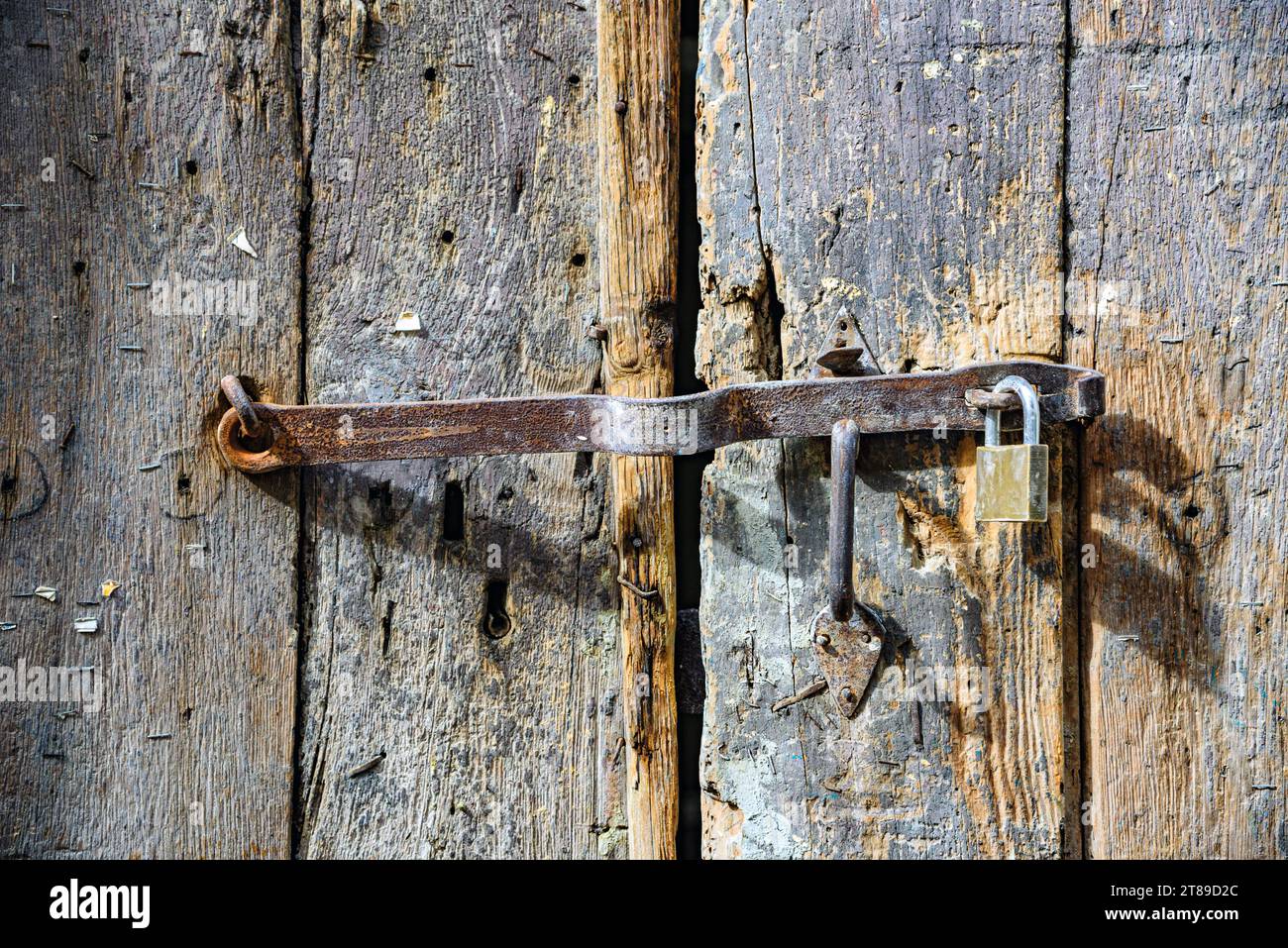 Vecchio chiavistello in metallo con serratura su un cancello in legno Foto Stock