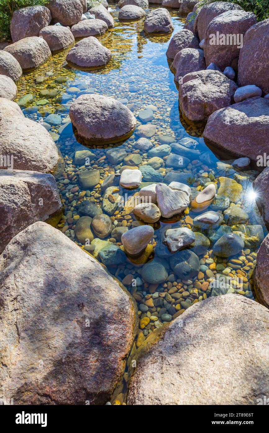 Piccolo laghetto in un giardino come elemento di design paesaggistico con roccia, ciottoli e ghiaia Foto Stock
