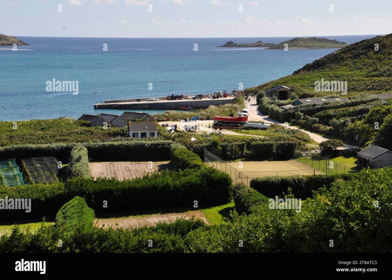 Vista dalla città vecchia sull'isola di St Martins verso la nuova banchina con piccoli campi fiancheggiati da alte siepi di Pittisporum per la protezione dal vento. Un tenni Foto Stock