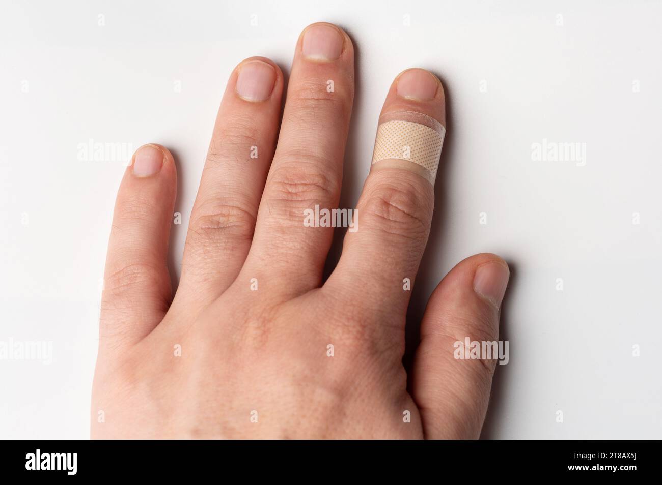 Taglio ricoperto con fascia medica su una mano dell'uomo vista ravvicinata isolata Foto Stock