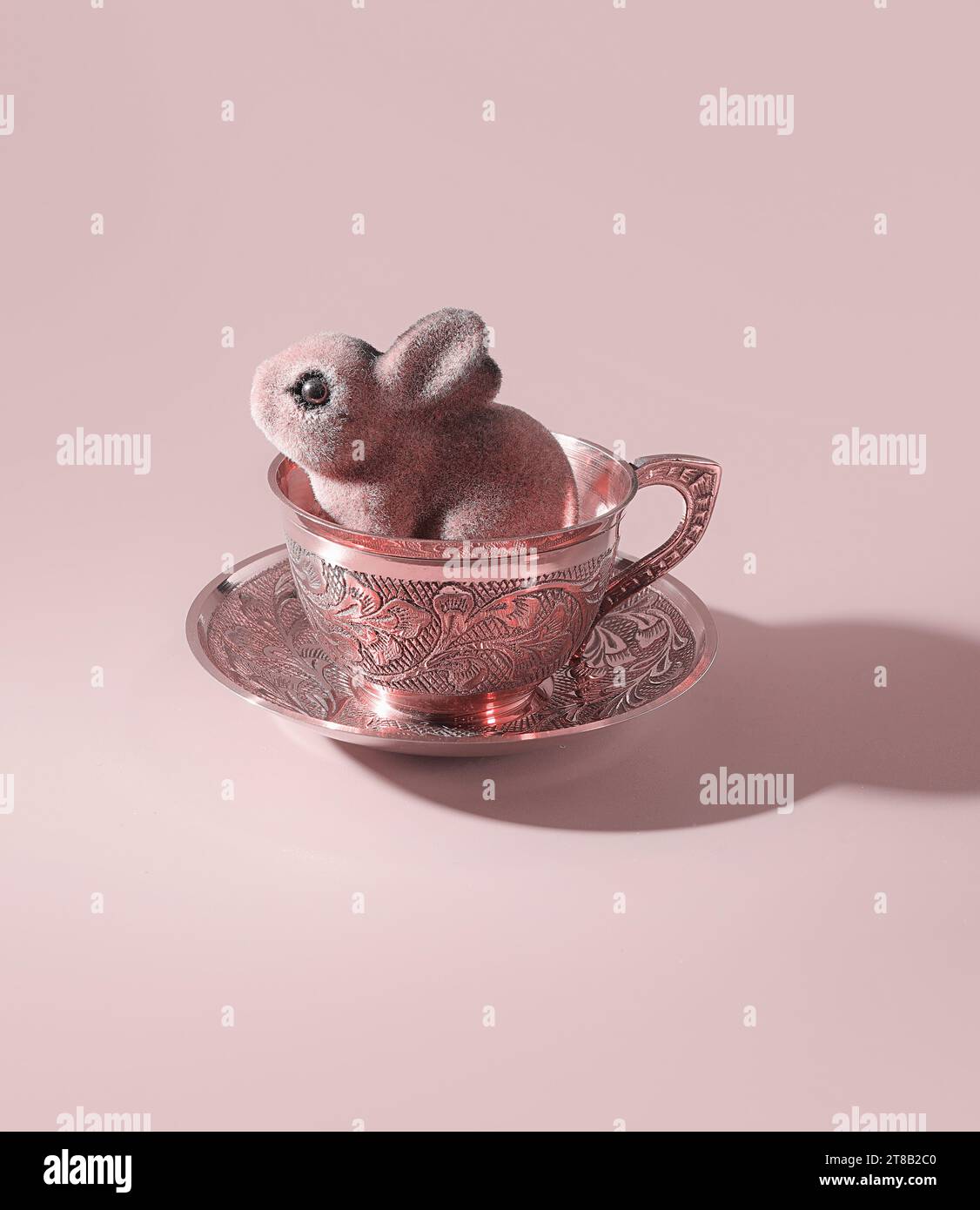 Festa del tè di Pasqua: Un simpatico coniglio pasquale in una tazza da tè oro rosa decorata, tè pomeridiano, tè pomeridiano, festa del tè, concetto di celebrazione pasquale Foto Stock