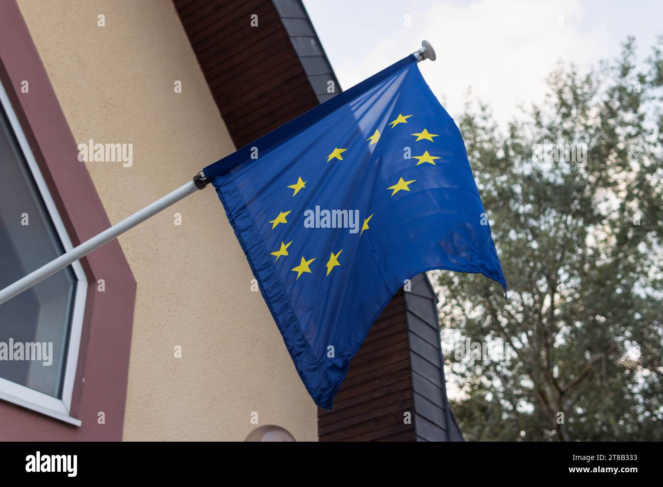 Battendo bandiera UE sul muro dell'edificio bandiera UE che sbatte nel vento da vicino Foto Stock