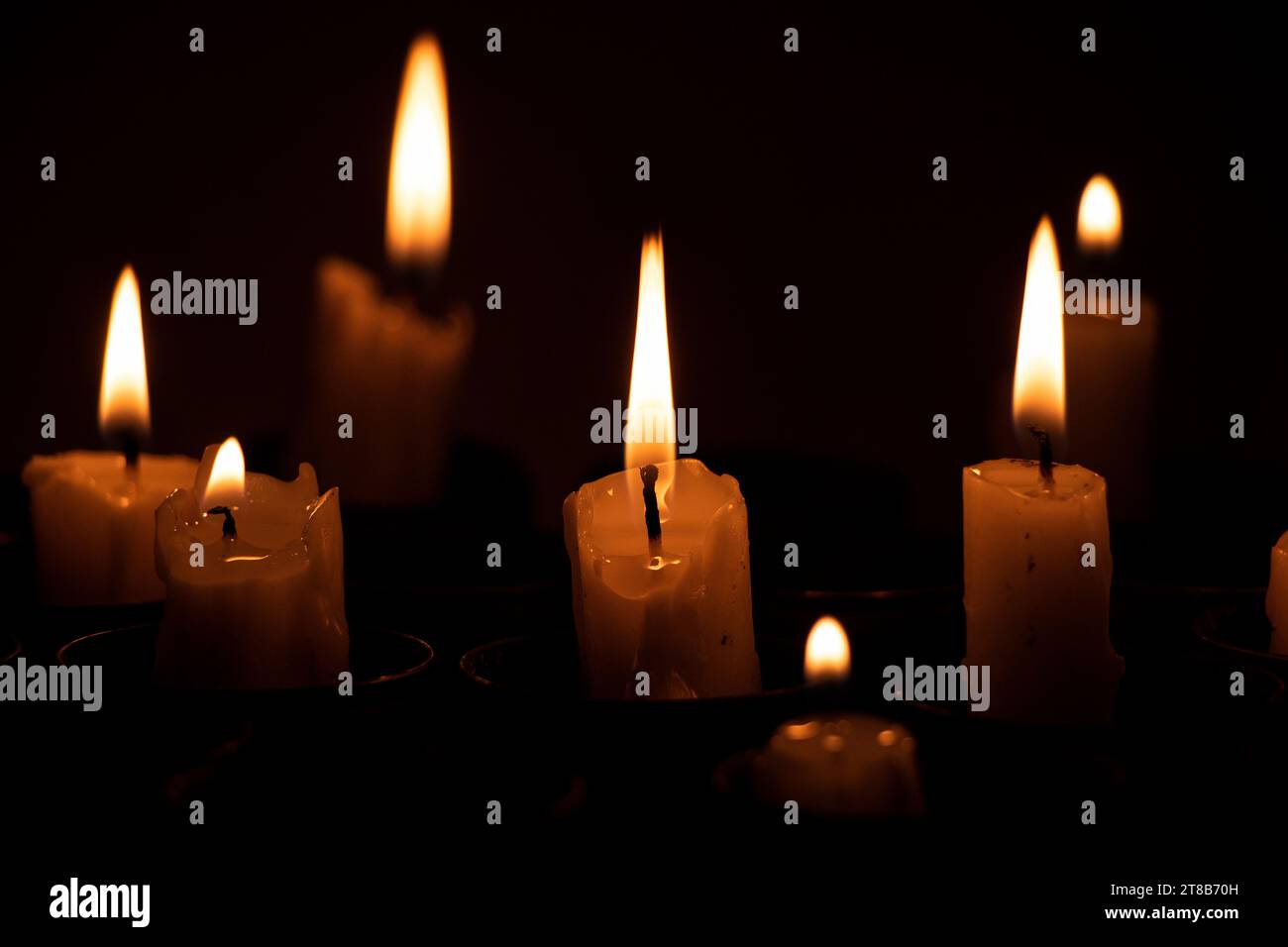 Le candele incendiate si trovano in involucri di lanciagranate sprecati al buio, tristezza per coloro che sono stati uccisi nella guerra in Ucraina Foto Stock
