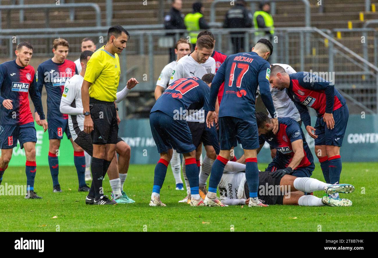 Sport, calcio, Regional League West, 2023/2024, Wuppertaler SV vs. 1. FC Bocholt 1-2, scena della partita, Malek Fakhro (FC) è infortunato e si trova in agguato, l'arbitro Cengiz Kabalakli e i giocatori di entrambe le squadre si prendono cura di lui Foto Stock