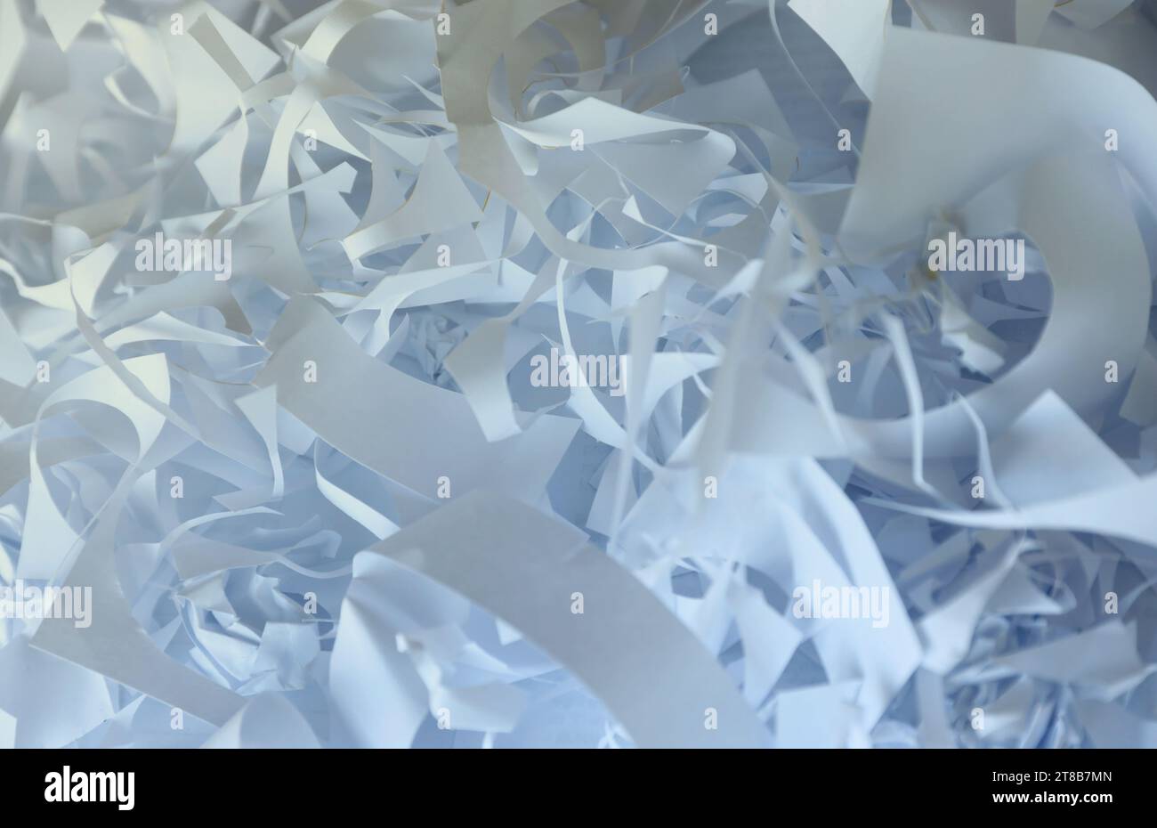 Sfondo con trama di carta triturata, vista dall'alto di molte strisce di carta bianca. Pile di carta tagliata come i corietti per feste o il riempitivo per scatole per la spedizione di articoli fragili Foto Stock