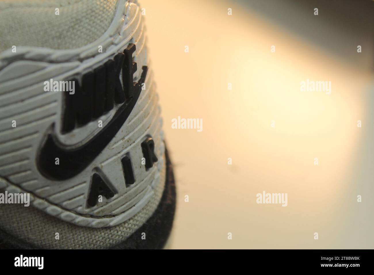 Una foto di un paio di scarpe Nike Air Max 90 bianche sporche su una superficie bianca. Foto Stock