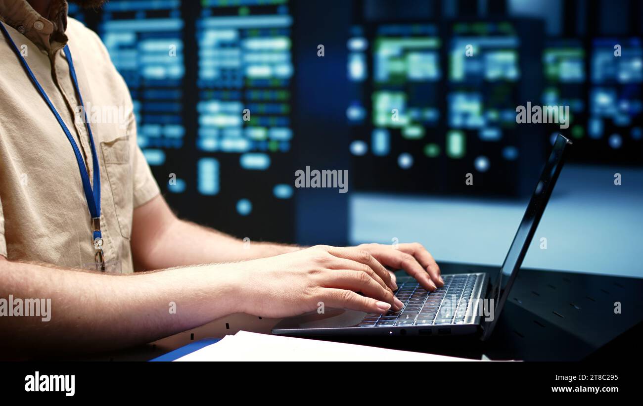 Responsabile dell'esecuzione di test diagnostici delle apparecchiature del data center per determinare ed eseguire il debug dei problemi del software. Riparatore che utilizza un notebook per analizzare i sistemi critici, verificare l'eventuale presenza di arresti anomali, primo piano Foto Stock